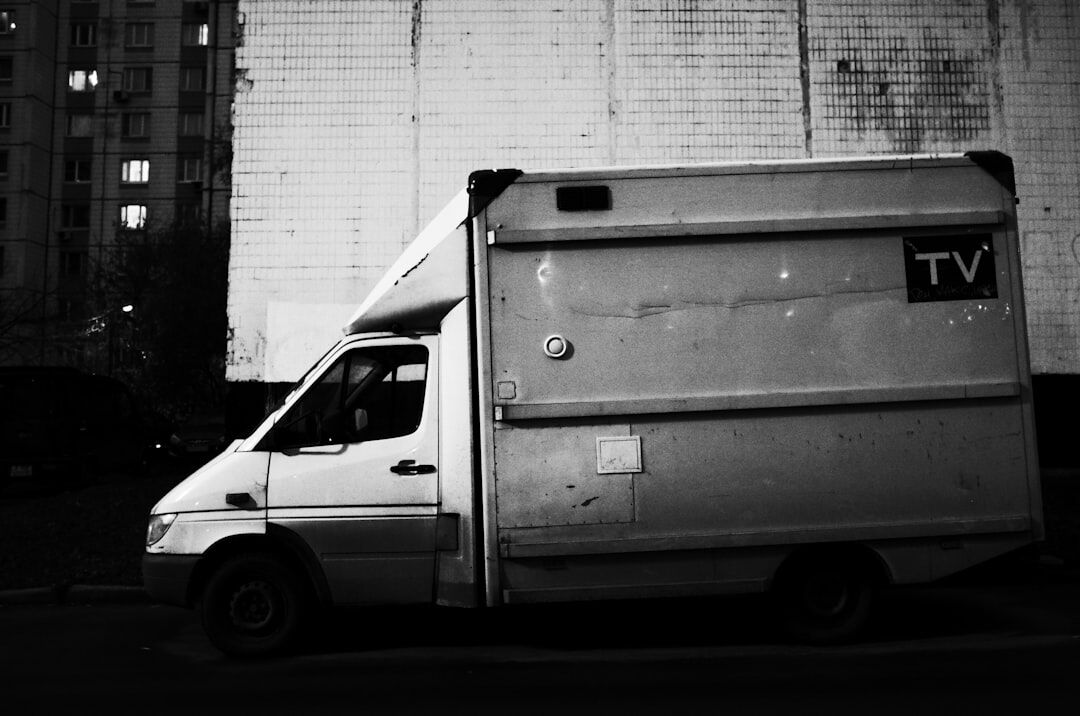 Outside broadcast van with satellite dish at night
